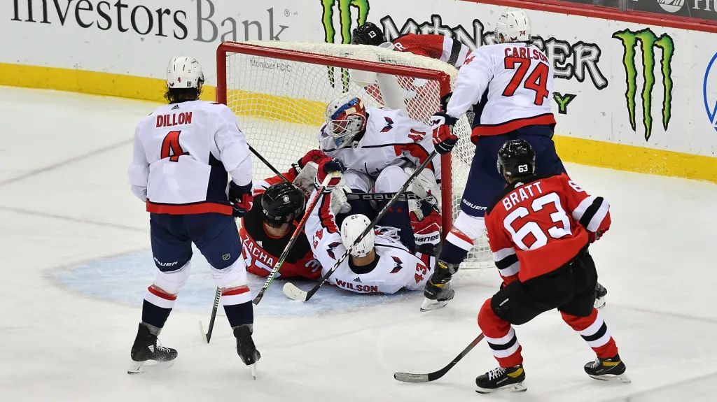 Útočník Pavel Zacha z New Jersey v kontaktu s brankářem Washingtonu Vítkem Vaněčkem