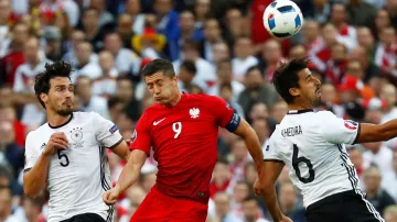 Polák Robert Lewandowski v hlavičkovém souboji s Němci Sami Khedirou and Matsem Hummelsem