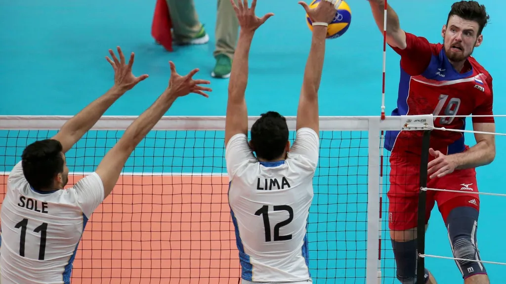 Argentinští volejbalisté se snaží zablokovat smeč Rusa Jegora Kljuky