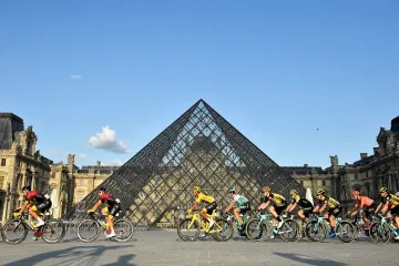 Cyklisté na Tour de France projíždí kolem muzea Louvre