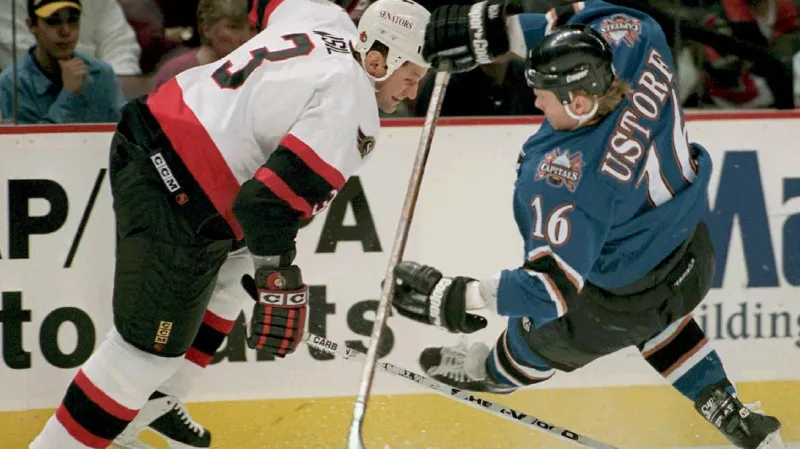 František Musil v dresu Ottawy (vlevo) v souboji o puk se Stefanem Ustorfem z Washingtonu