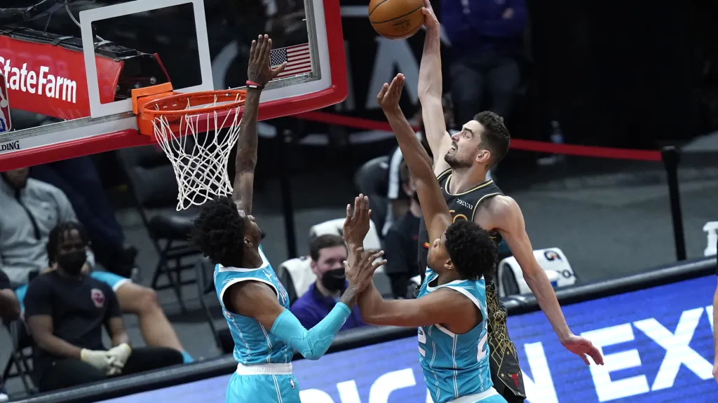 Tomáš Satoranský smečuje přes Jalena McDanielse a Vernona Careyho Jr. z Charlotte