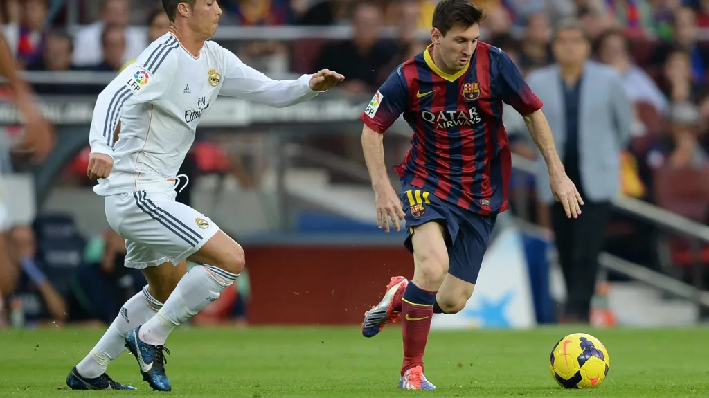Barcelonský Lionel Messi (vpravo) uníká s míčem Cristanovi Ronaldovi z Realu Madrid