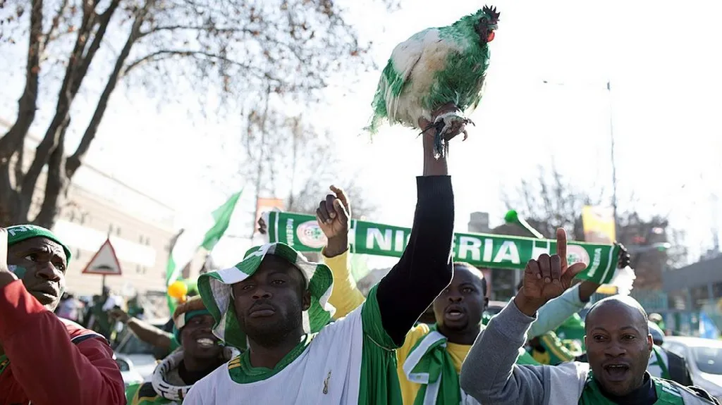 Nigerijští fanoušci s talismanem v podobě slepice