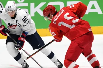 Americký útočník Patrick Kane bráněný Arťomem Anisimovem