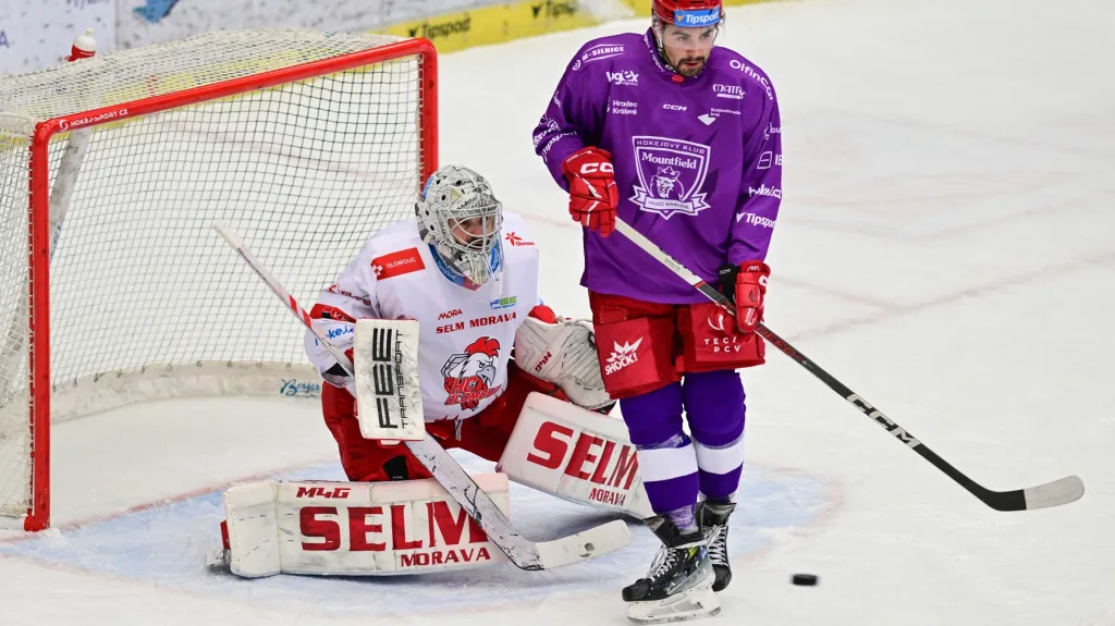 Olomoucký brankář Matěj Machovský nahlíží přes hradeckého Patrika Miškáře