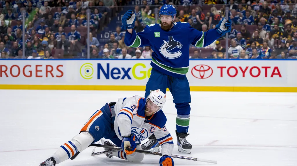 Filip Hronek z Vancouveru v souboji s Connorem McDavidem z Edmontonu