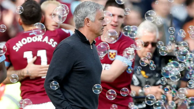 Manažer Manchesteru United José Mourinho jde kolem slavících hráčů West Hamu