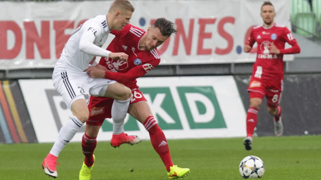 Karvinský Filip Panák (vlevo) bojuje o míč s Martinem Nešporem z Olomouce