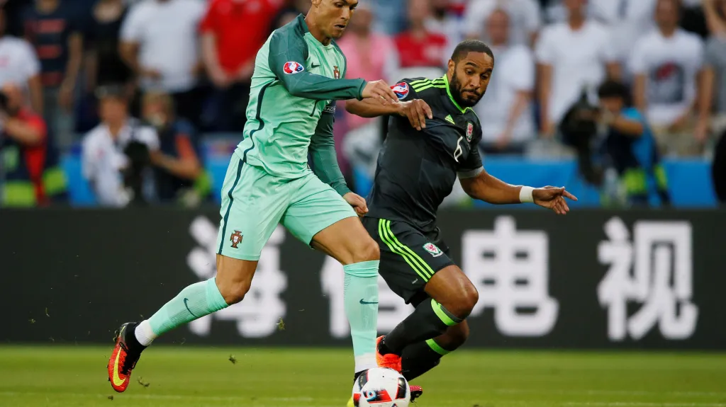 Portugalec Cristiano Ronaldo (vlevo) se snaží uniknout Ashley Williamsovi z Walesu