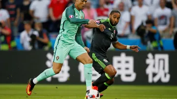 Portugalec Cristiano Ronaldo (vlevo) se snaží uniknout Ashley Williamsovi z Walesu