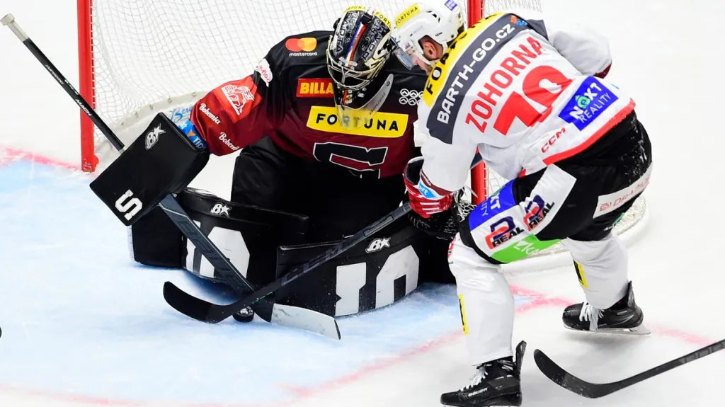 Brankář Sparty Jakub Kovář zasahuje proti pardubickému Tomáši Zohornovi