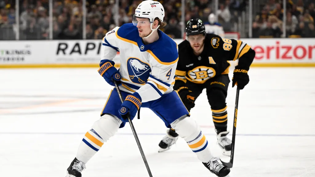 David Pastrňák stíhá střelce jednoho z gólů Buffala Bowena Byrama