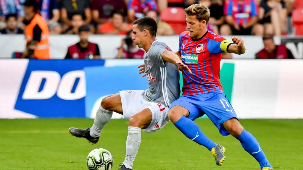 Daniel Podence z Olympiakosu si kryje míč před Patrikem Hrošovským z Plzně