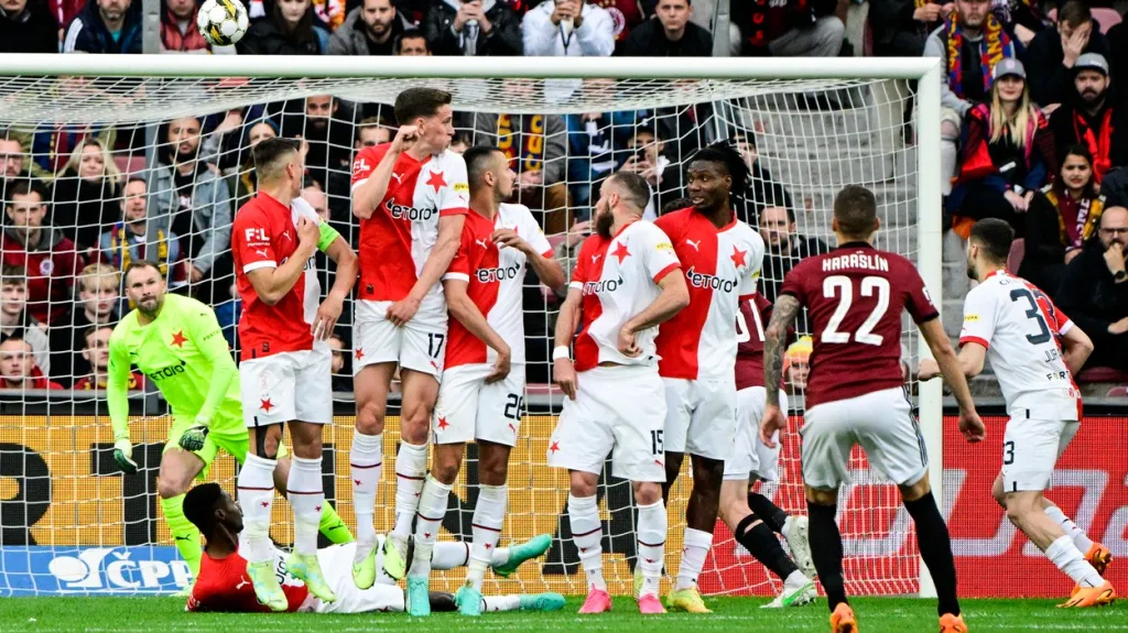 Fotbalisté Slavie sledují míč, který míří z kopačky Lukáše Haraslína ze Sparty do jejich sítě