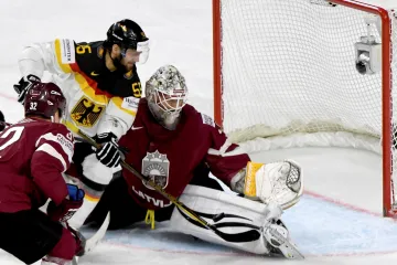 Lotyšský brankář Elvis Merzlikins v souboji s Felixem Schutzem z Německa