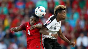 Portugalec William Carvalho v hlavičkovém souboji s Davidem Alabou