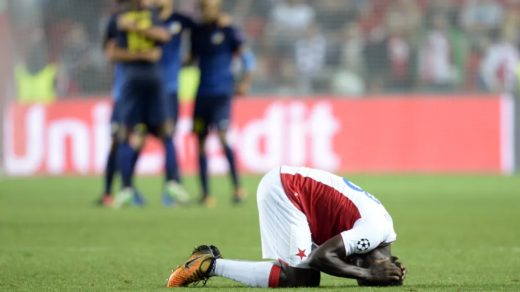 Smutnící Ngadeu a v pozadí slavící hráči APOELu