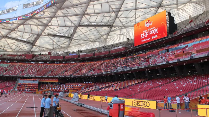 Čištění dráhy Mondo na olympijském stadionu v Pekingu