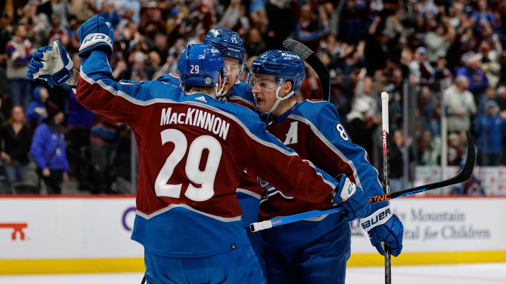 Nathan MacKinnon oslavuje se spoluhráči z Colorada gól v NHL