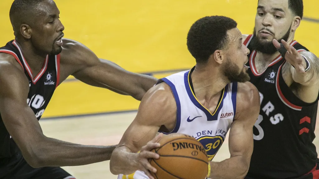 Hvězda Golden State Stephen Curry bráněný hráči Toronta