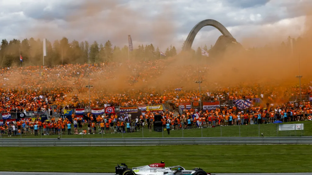 Lewis Hamilton projíždí v Rakousku před tribunou fanoušků, kteří podporují Maxe Verstappena