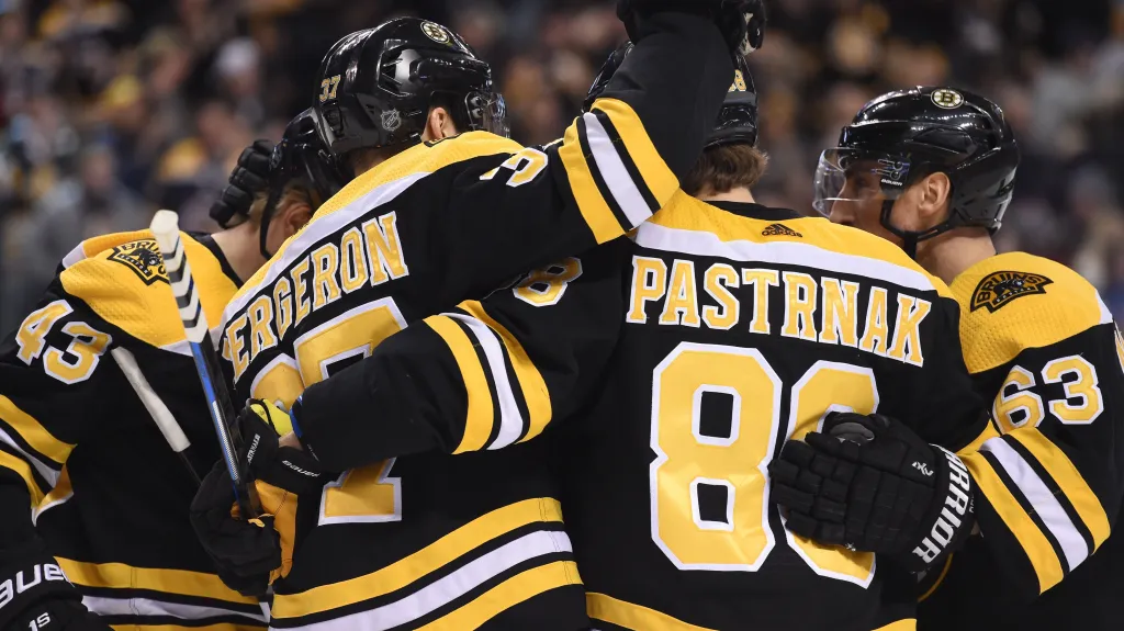 David Pastrňák v objetí spoluhráčů z Bostonu