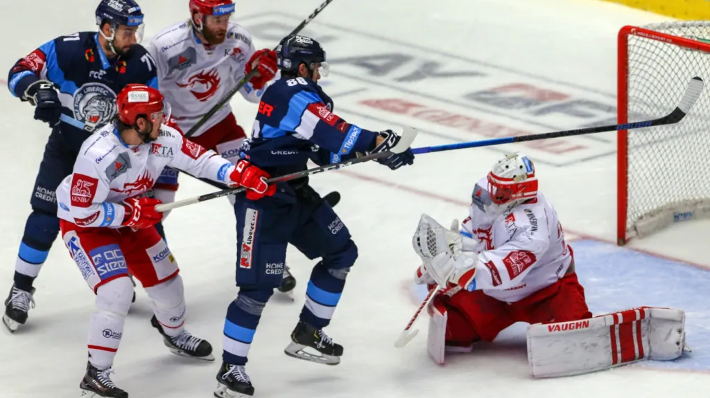 Třinecký gólman Šimon Hrubec zasahuje před dotírajícími hráči Liberce