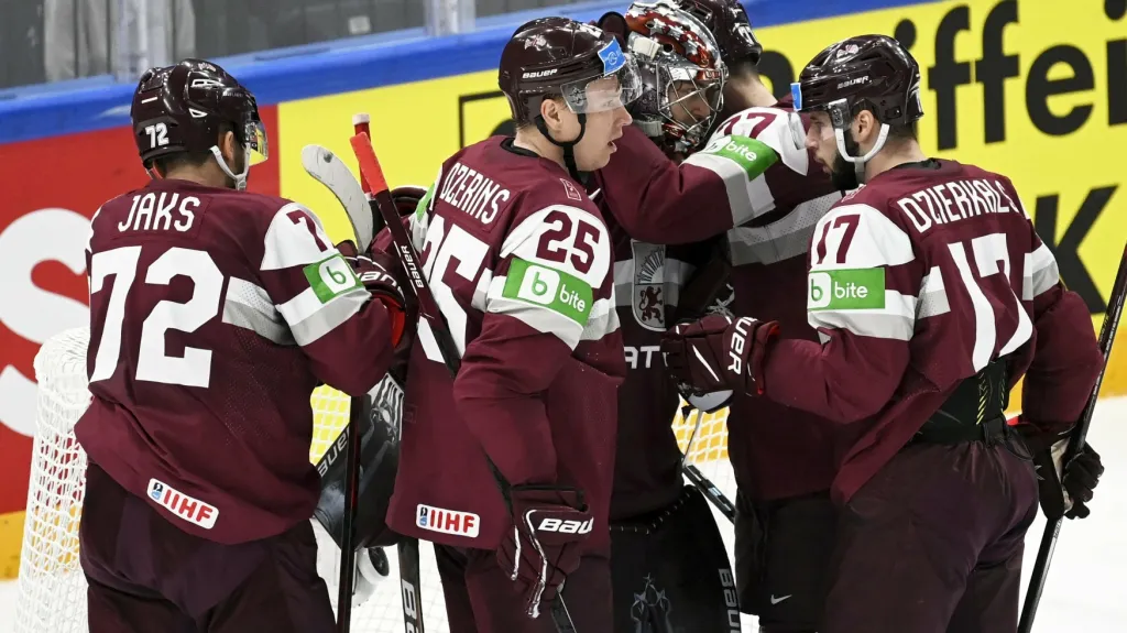 Hokejisté Lotyšska oslavují s brankářem Merzlikinsem výhru