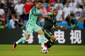 Portugalec Cristiano Ronaldo (vlevo) se snaží uniknout Ashley Williamsovi z Walesu