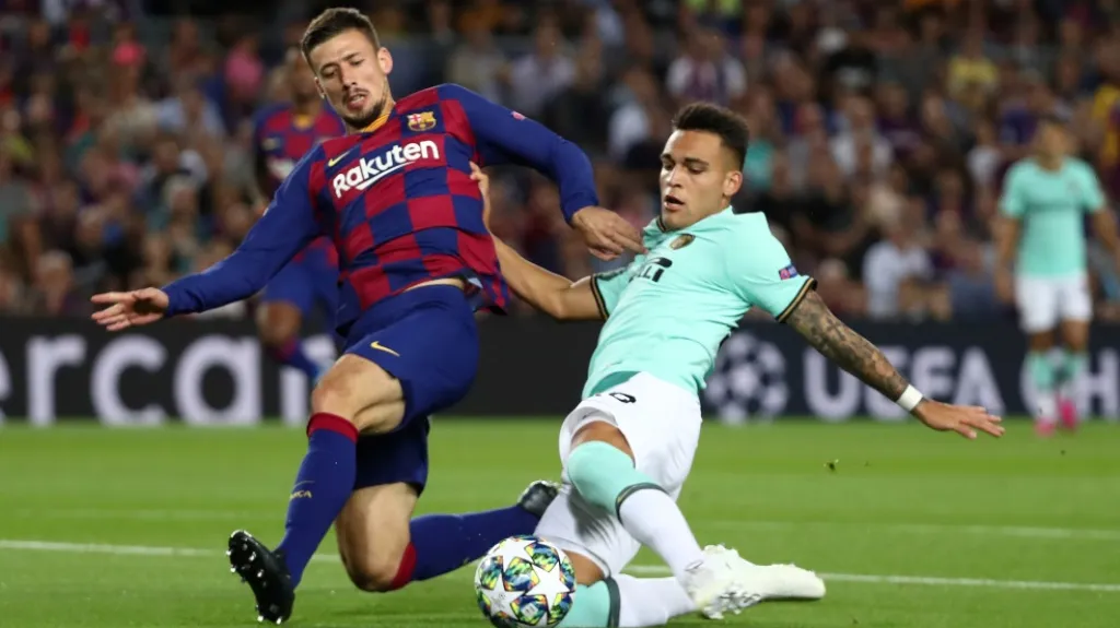 Martínez z Interu Milán v souboji s barcelonským obráncem Lengletem