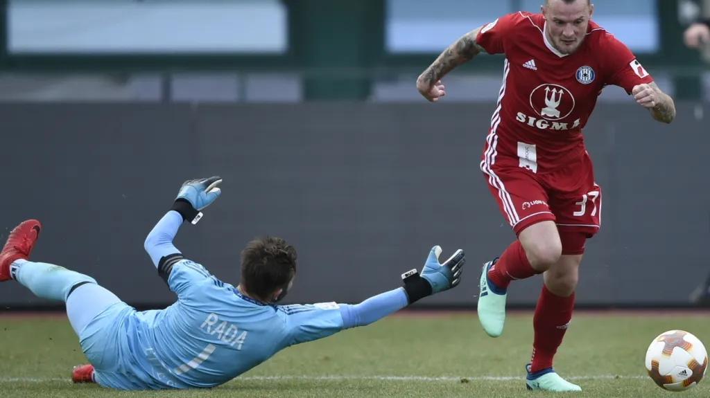 Olomoucký Jakub Řezníček obchází brankáře Dukly Filipa Radu