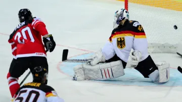 Cody Eakin z Kanady (vlevo) střílí gól. Vpravo je německý brankář Dennis Endras