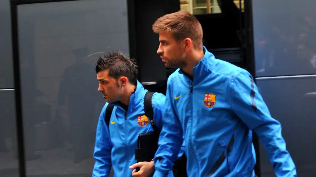Gerard Piqué a David Villa vystupují z autobusu před pražským hotelem Four Seasons